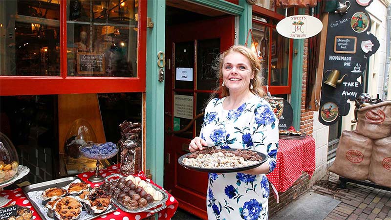 women outside shop holding cake